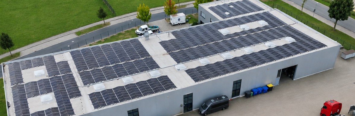 Photovoltaikanlage auf dem Flachdach einer Gewerbehalle aus der Luft