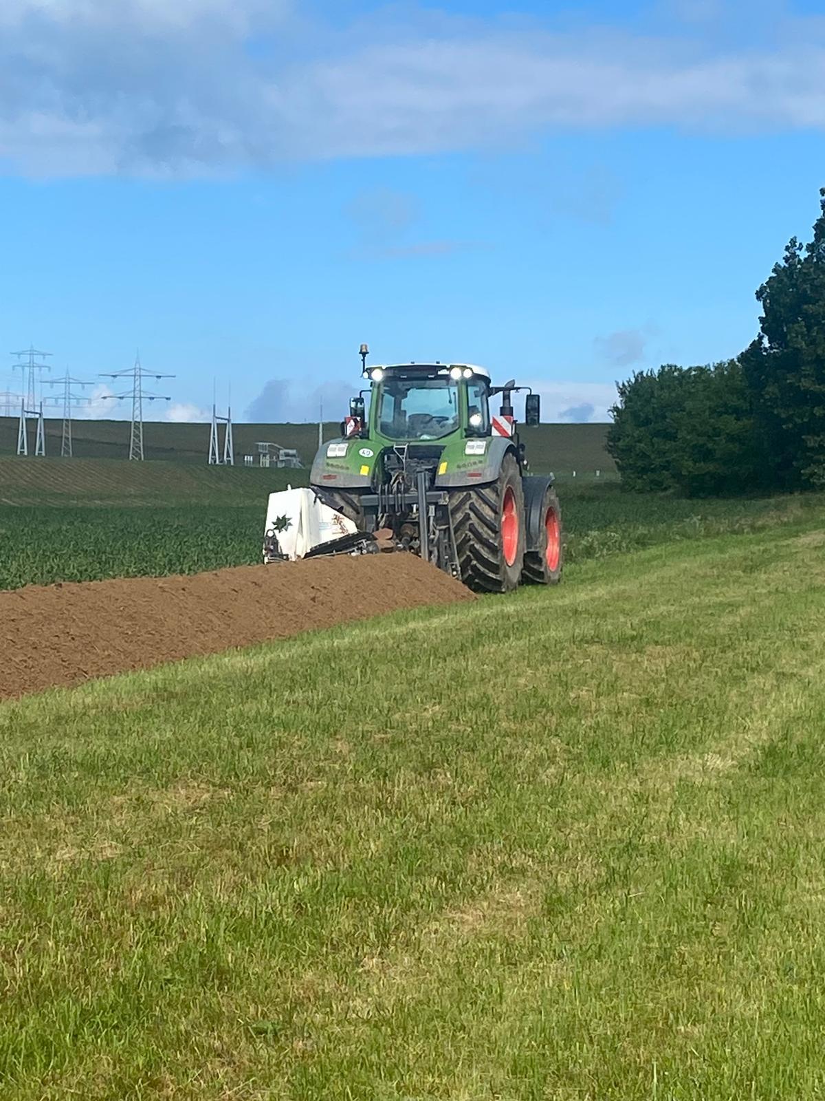 Fendt Traktor von hinten beim Ziehen eines Kabelgrabens